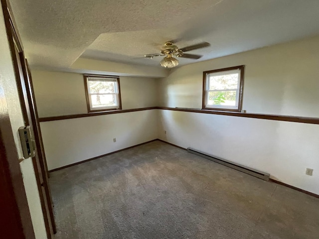 carpeted spare room with a textured ceiling, a healthy amount of sunlight, ceiling fan, and a baseboard radiator