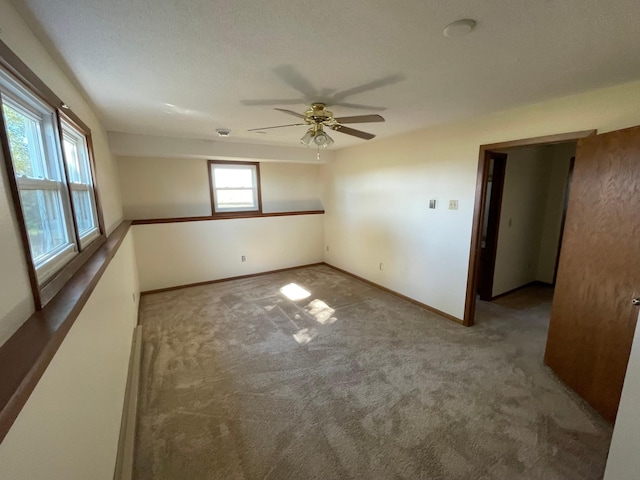 carpeted spare room with ceiling fan and a textured ceiling