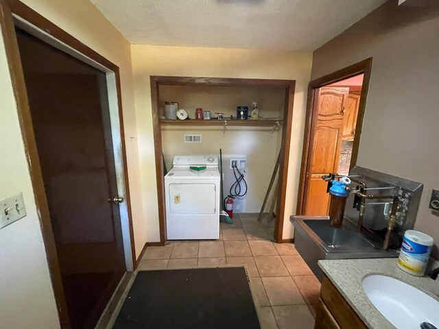 laundry room with washer / clothes dryer, light tile patterned floors, and sink