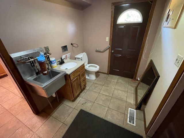 bathroom with vanity, tile patterned floors, and toilet