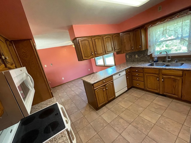 kitchen featuring range, sink, kitchen peninsula, light tile patterned floors, and white dishwasher