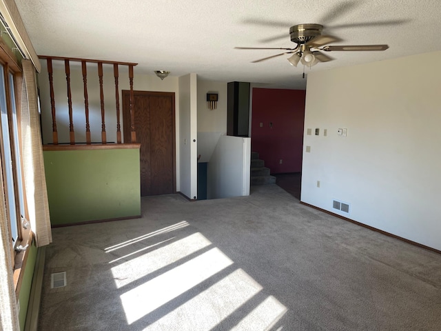 interior space with ceiling fan, a textured ceiling, and carpet floors