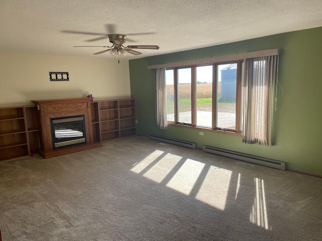 unfurnished living room with a baseboard heating unit, ceiling fan, carpet flooring, and a textured ceiling