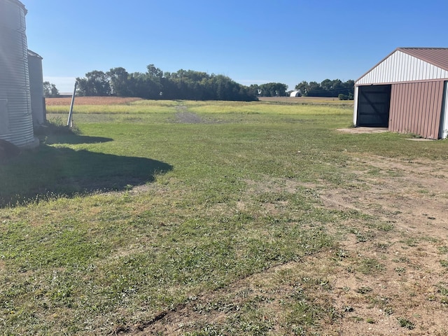 view of yard with a rural view and an outdoor structure