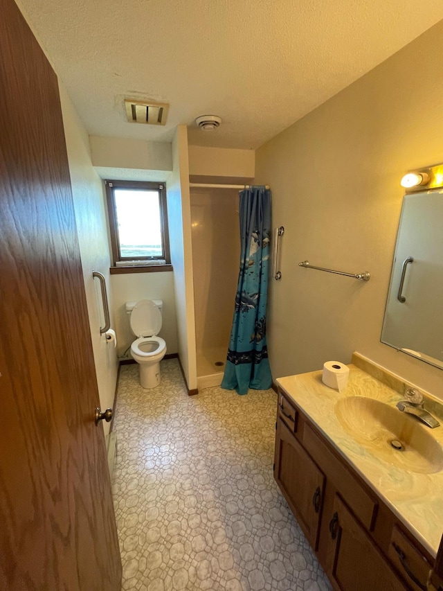 bathroom with a shower with curtain, a textured ceiling, vanity, and toilet