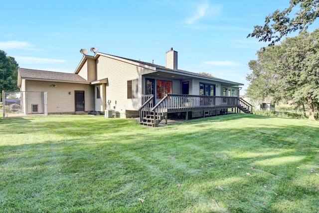 back of property with a lawn, a wooden deck, and central AC