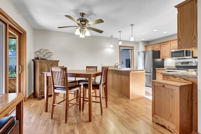 dining space with ceiling fan, sink, and light hardwood / wood-style floors