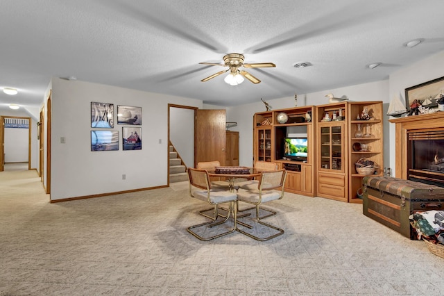 carpeted dining area featuring ceiling fan and a textured ceiling