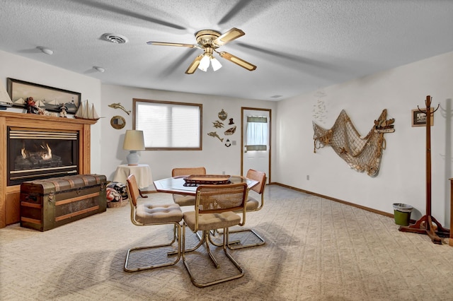 dining room featuring a textured ceiling, light carpet, and ceiling fan