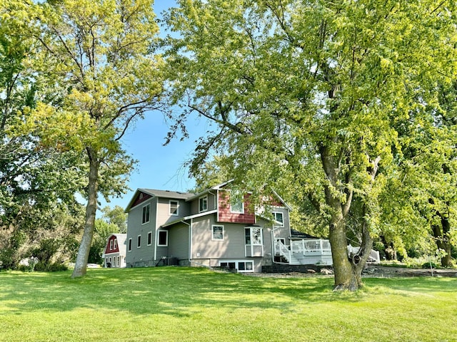 rear view of property with a wooden deck and a yard