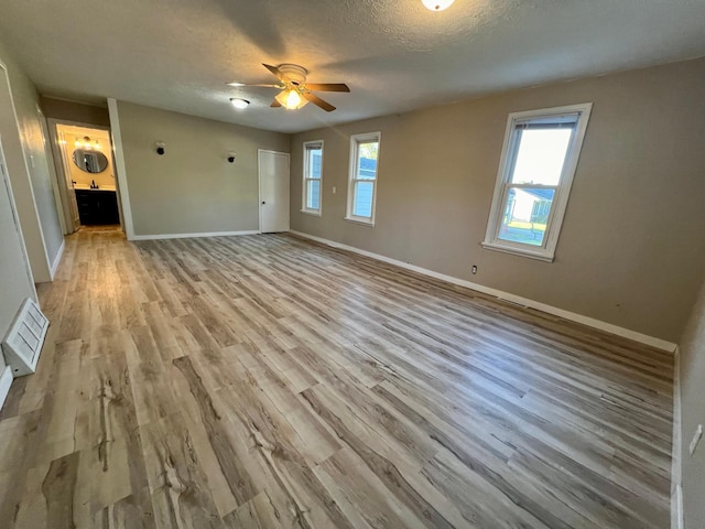 interior space featuring a wealth of natural light, light hardwood / wood-style floors, ceiling fan, and a textured ceiling