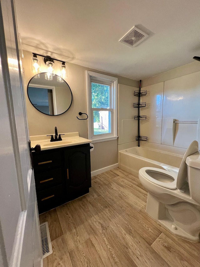 full bathroom with bathing tub / shower combination, hardwood / wood-style flooring, vanity, and toilet