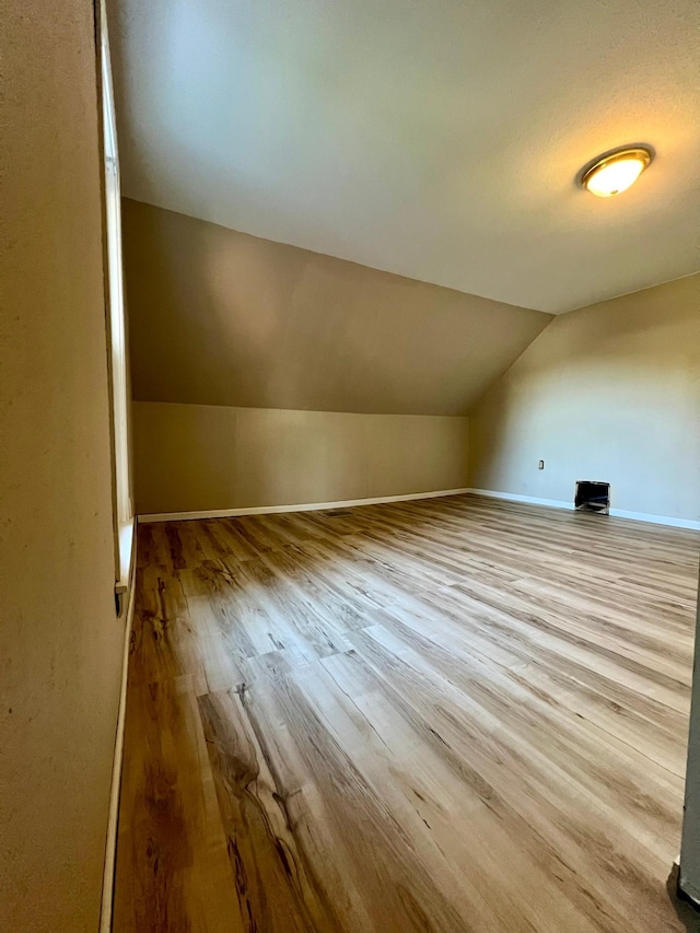 bonus room with vaulted ceiling and light hardwood / wood-style floors