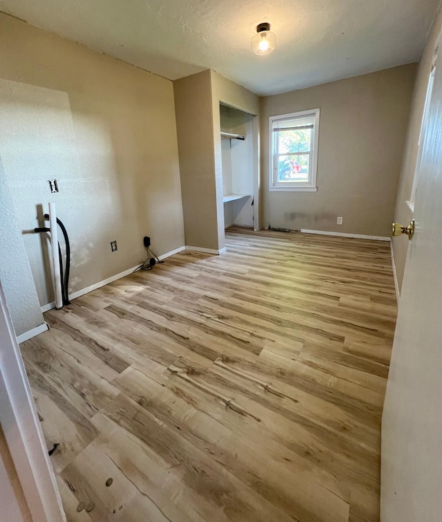 511 Division St N, Clara City, MN 56222 - unfurnished bedroom with baseboards, a closet, and wood finished floors