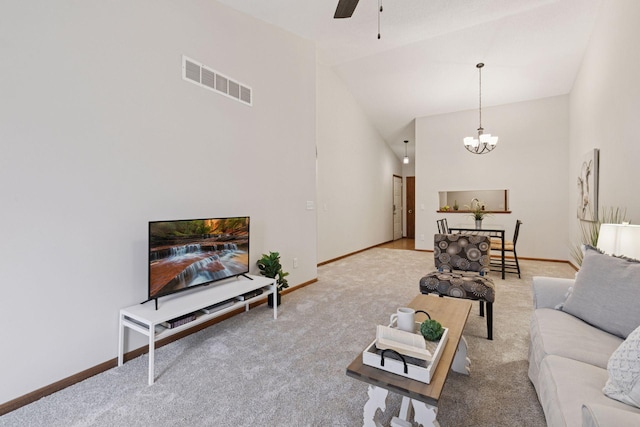 living room with high vaulted ceiling, ceiling fan with notable chandelier, carpet, baseboards, and visible vents
