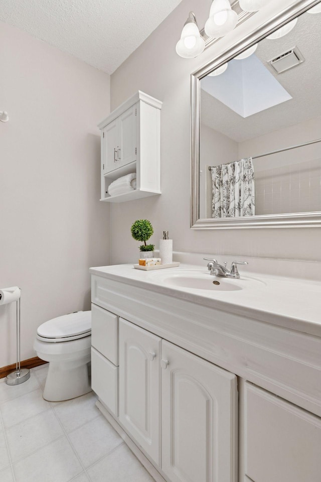 bathroom featuring a textured ceiling, vanity, toilet, tile patterned flooring, and visible vents