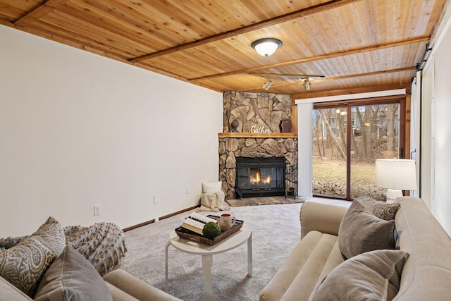 carpeted living room featuring wooden ceiling, baseboards, beam ceiling, and a stone fireplace