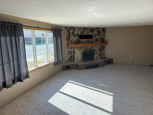 living room featuring carpet floors, a textured ceiling, and a stone fireplace