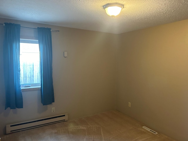 spare room with a baseboard heating unit, carpet, and a textured ceiling