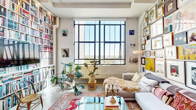 sitting room featuring concrete floors and brick wall