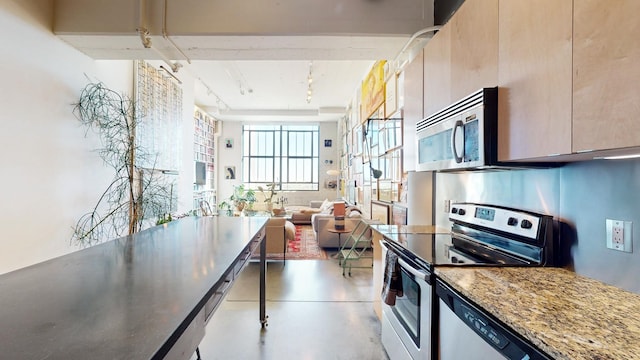 kitchen with light stone counters, appliances with stainless steel finishes, and light brown cabinets