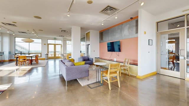 living room with track lighting and concrete flooring