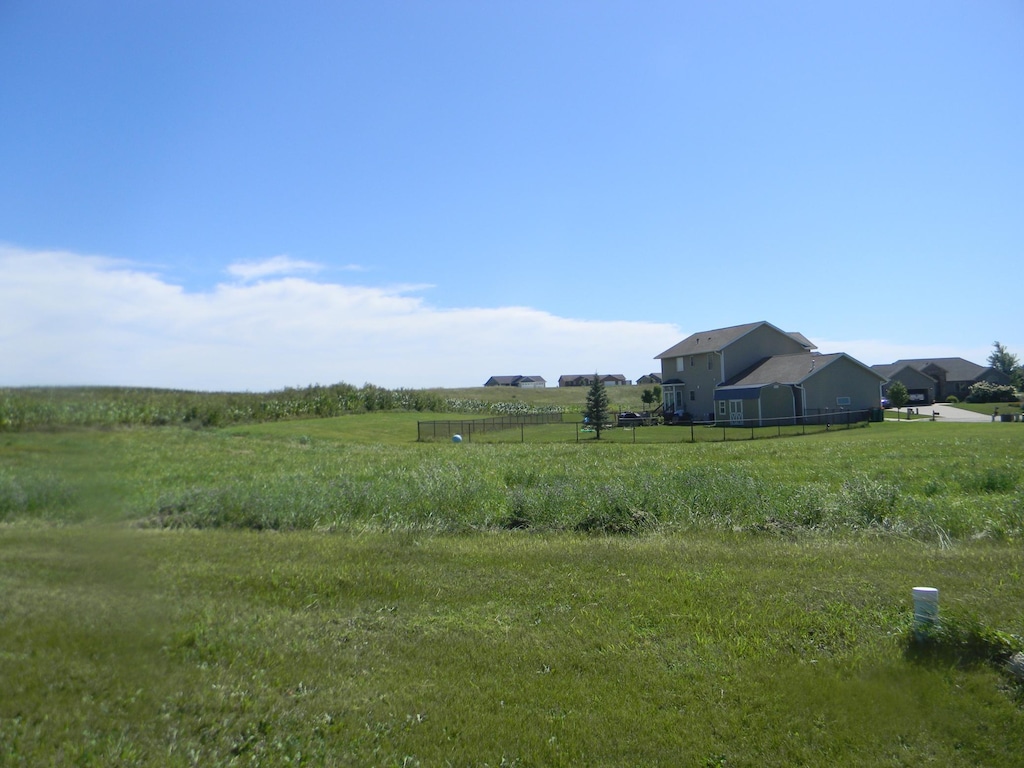 view of yard with a rural view and fence