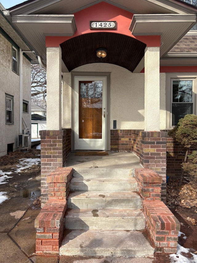 property entrance featuring brick siding and stucco siding