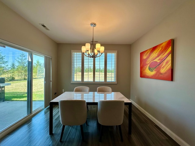 dining room featuring dark hardwood / wood-style flooring and a notable chandelier