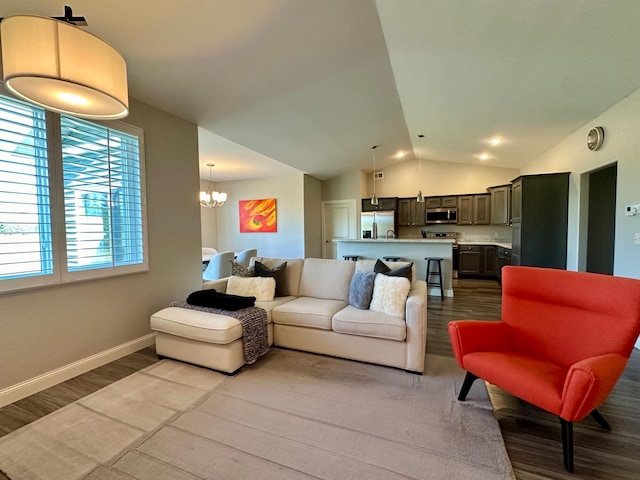 living room featuring an inviting chandelier, lofted ceiling, and light hardwood / wood-style floors