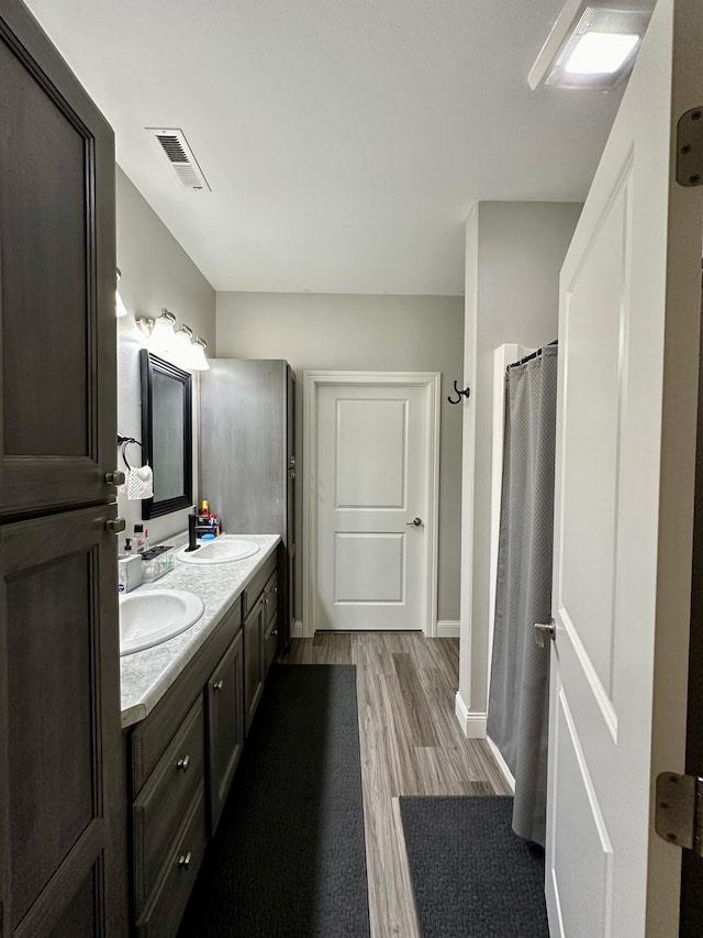 bathroom featuring wood-type flooring, a shower with curtain, and vanity