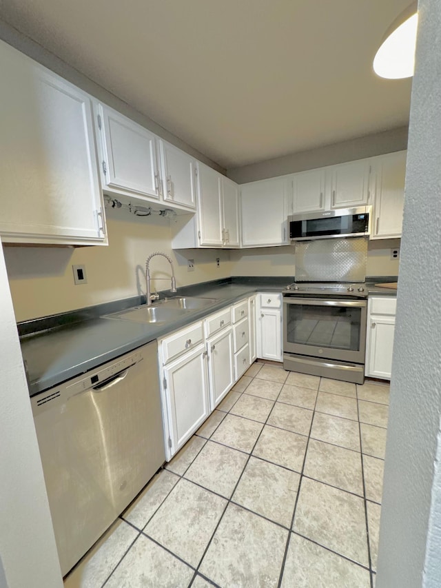 kitchen featuring stainless steel appliances, white cabinetry, and sink