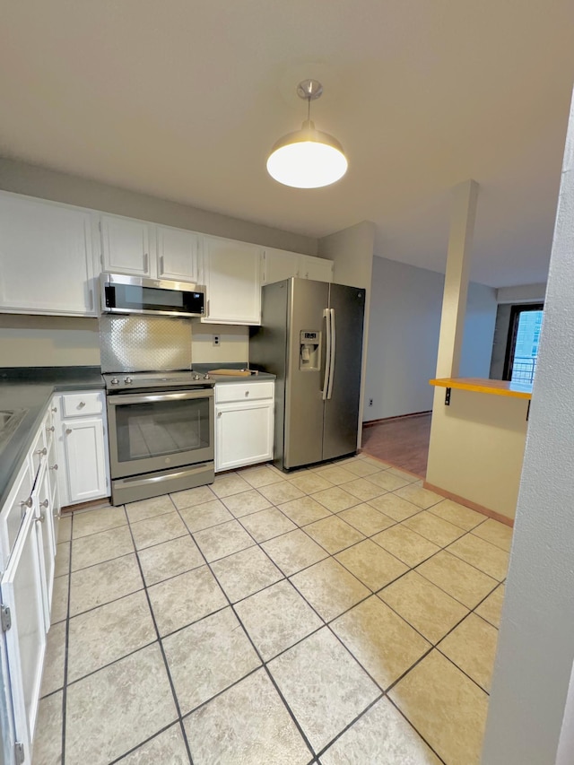 kitchen with white cabinetry, stainless steel appliances, range hood, and light tile patterned floors