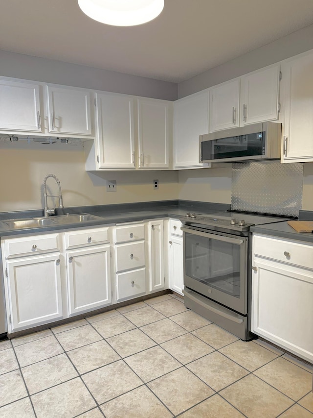 kitchen with appliances with stainless steel finishes, white cabinetry, and a sink