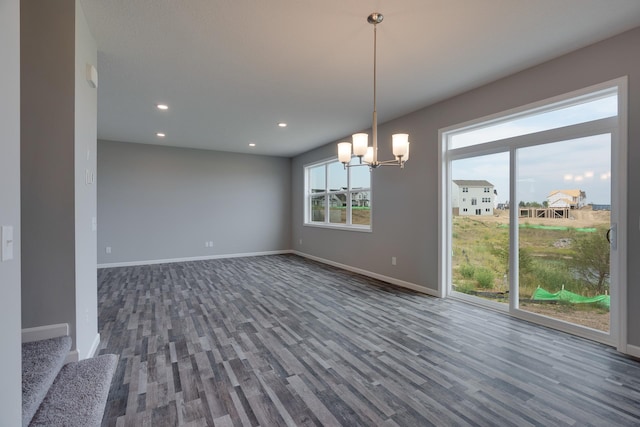 empty room featuring a notable chandelier and dark hardwood / wood-style floors