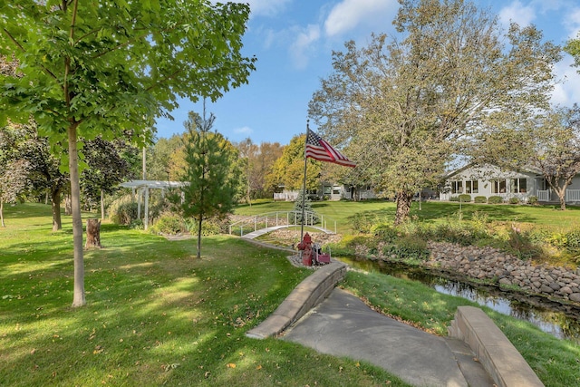 view of community featuring a water view and a yard