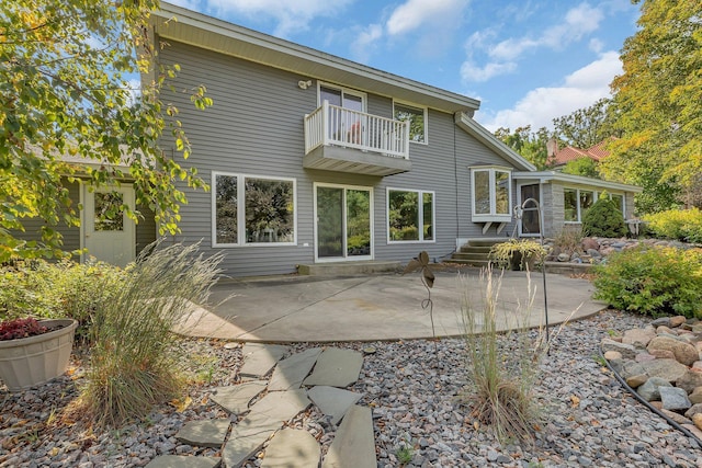 rear view of house with a patio area and a balcony