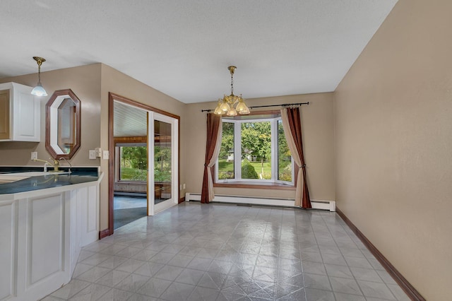 unfurnished dining area featuring a baseboard radiator, sink, and a textured ceiling