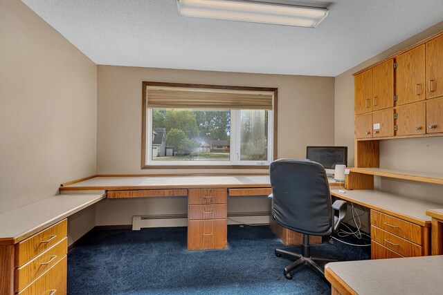 office with a textured ceiling, built in desk, a baseboard radiator, and dark colored carpet