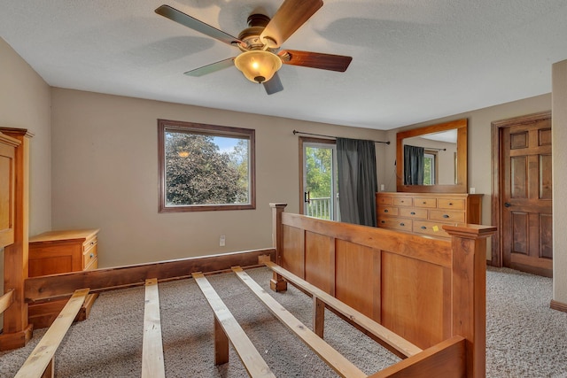 carpeted bedroom with a textured ceiling and ceiling fan