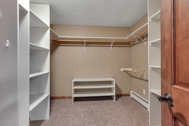 walk in closet with light colored carpet and baseboard heating