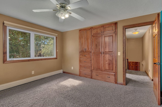 unfurnished bedroom featuring ceiling fan, carpet flooring, and a baseboard heating unit