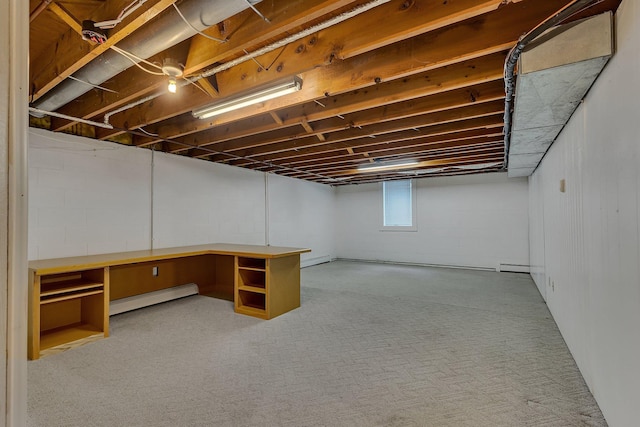 basement with baseboard heating and built in desk