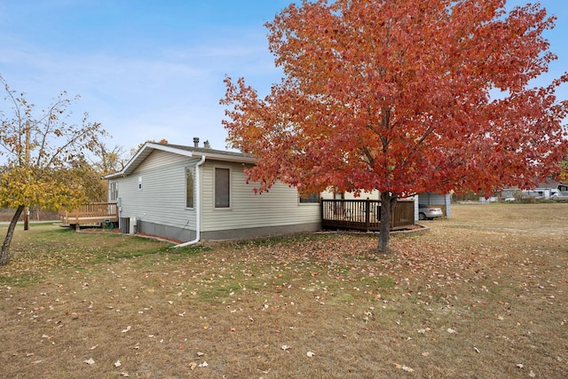 view of side of home featuring a lawn and a deck