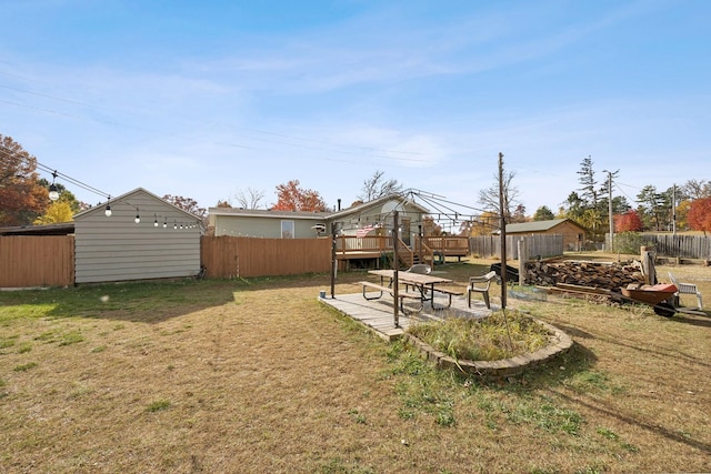 view of yard featuring a patio area, a storage unit, and a deck