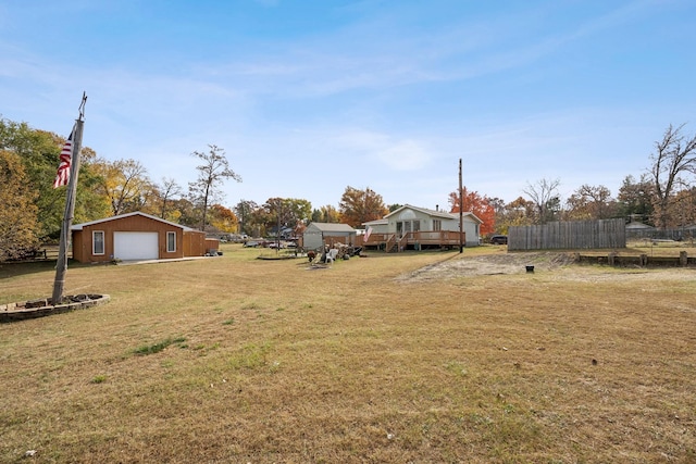 view of yard with a garage and an outbuilding