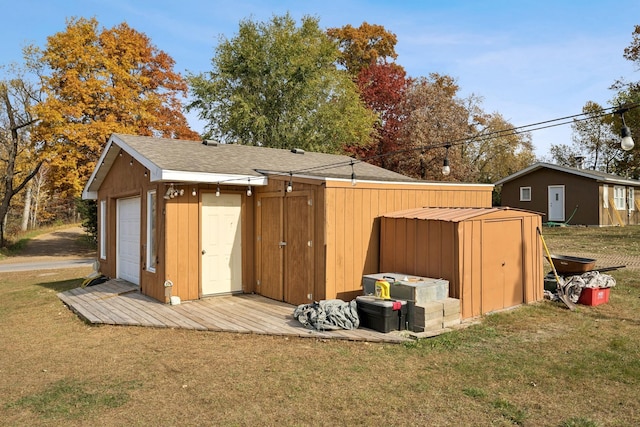 view of outdoor structure featuring a garage and a lawn