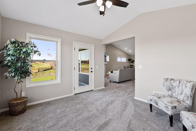 sitting room with light carpet, vaulted ceiling, and ceiling fan