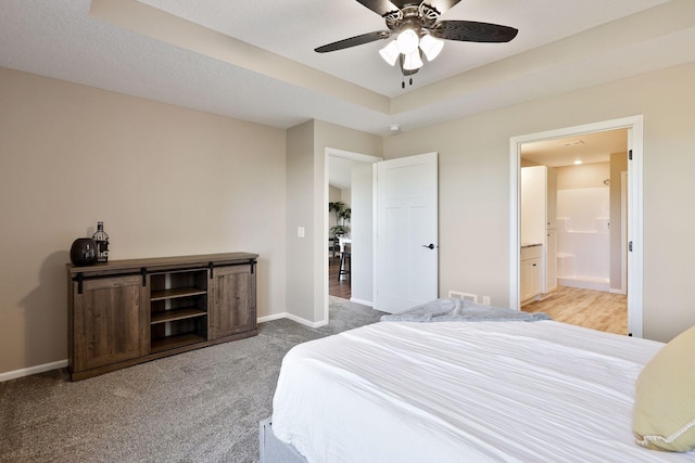 carpeted bedroom with ceiling fan, ensuite bathroom, and a textured ceiling