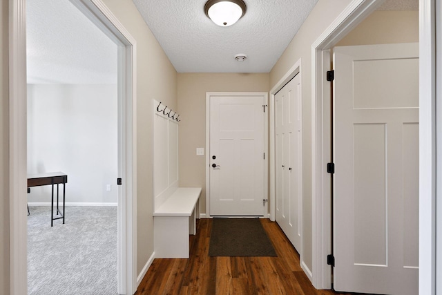 hallway featuring a textured ceiling and dark hardwood / wood-style flooring